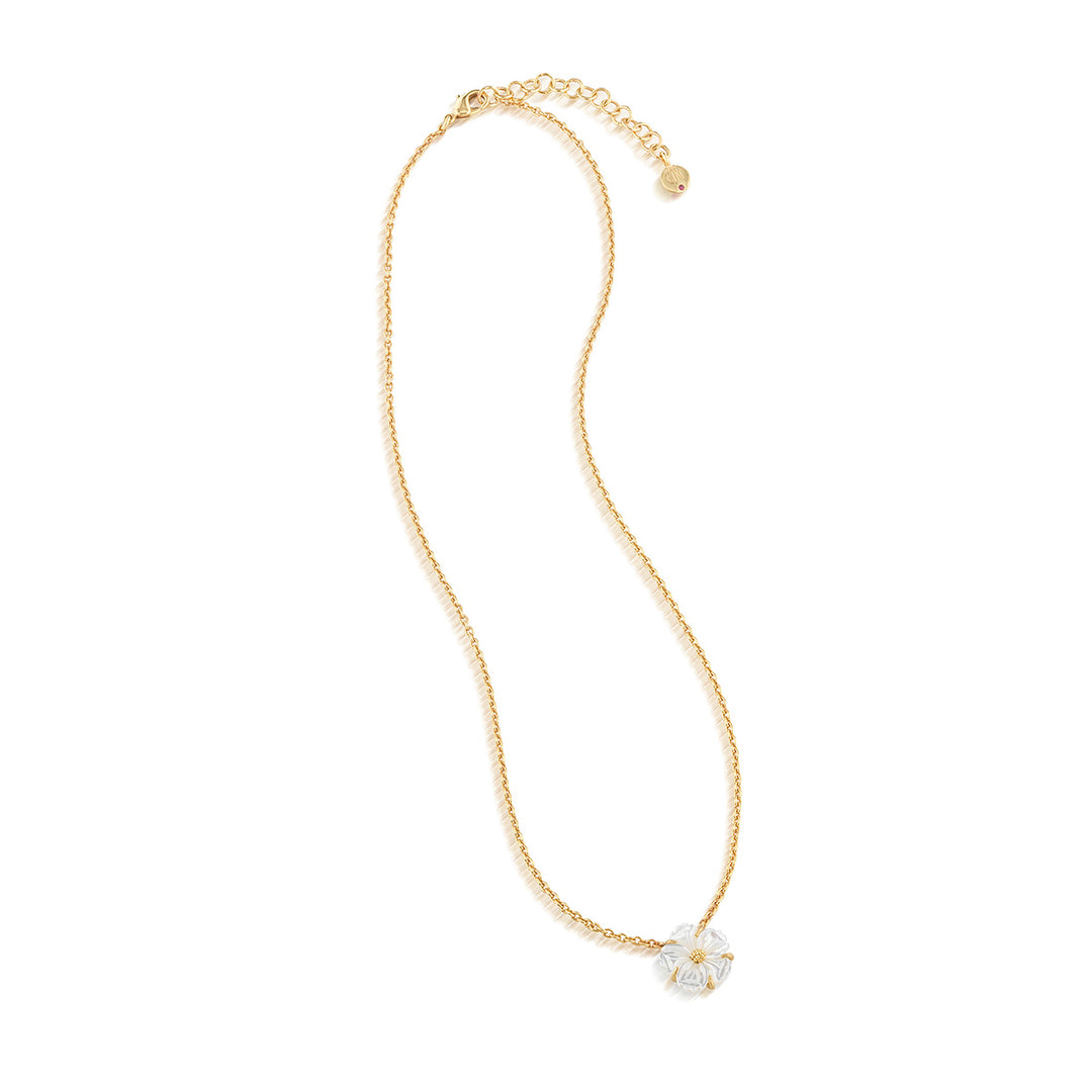 Gold necklace with a white floral pendant on a white background