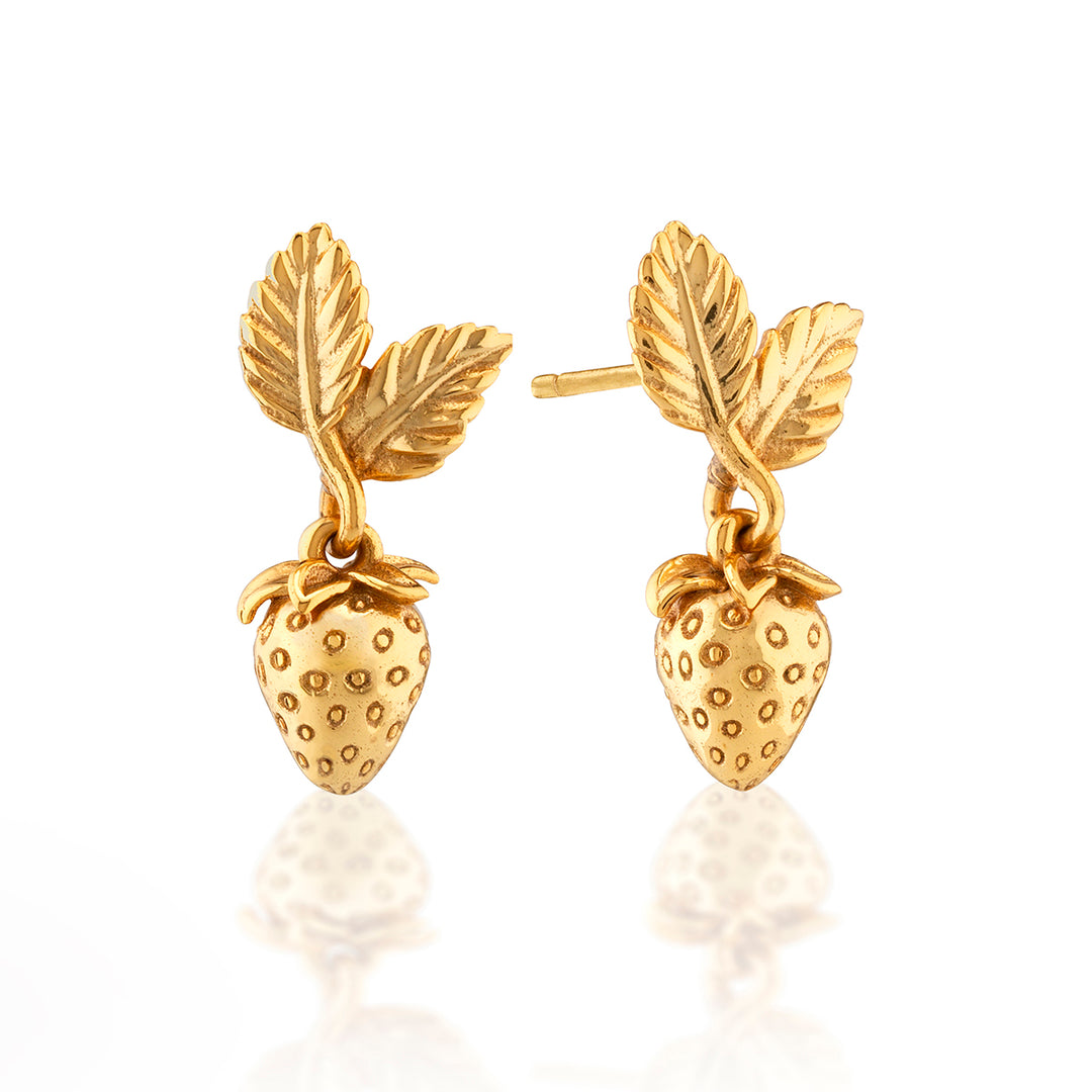 Gold strawberry-shaped earrings with leaf details on a white background