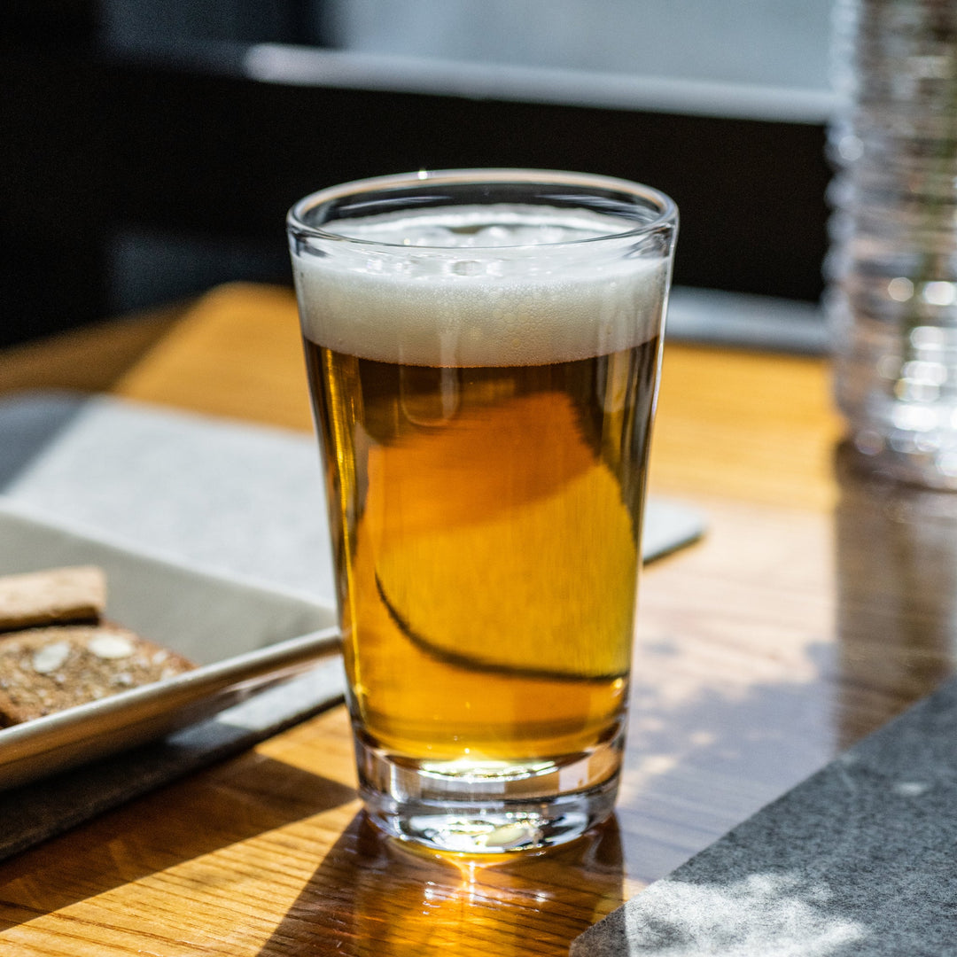 Glass of beer with foam on a wooden table