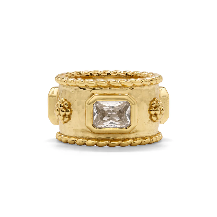 Gold ring with a clear gemstone and berry accents on a white background