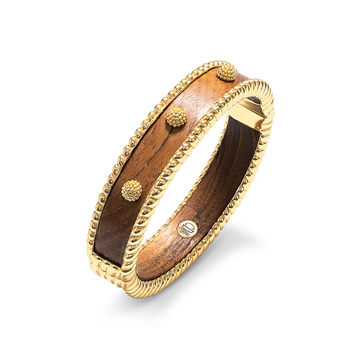 Wooden bracelet with gold berry and thread accents on a white background