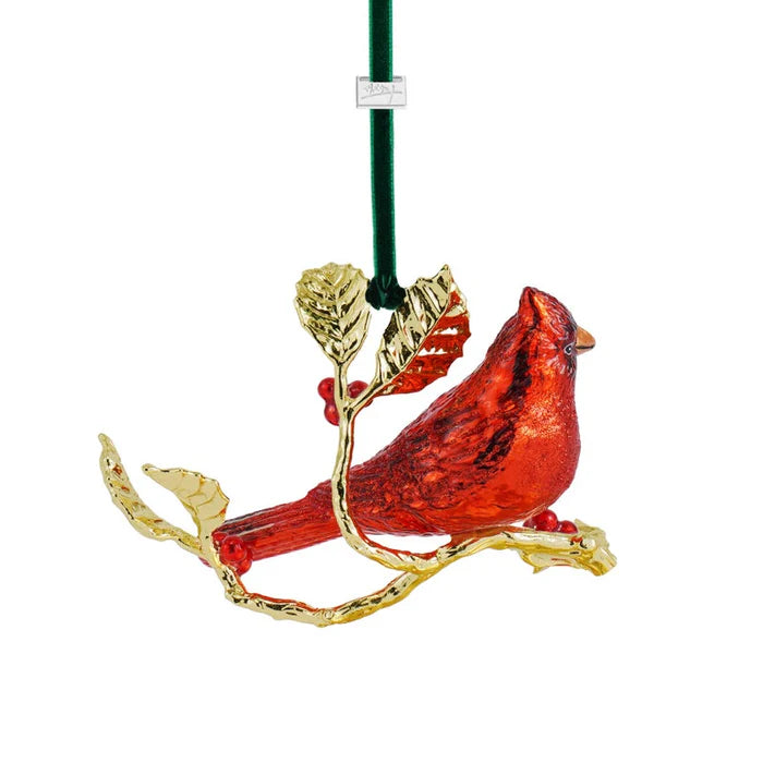 Red cardinal bird ornament on a branch with gold accents on a white background