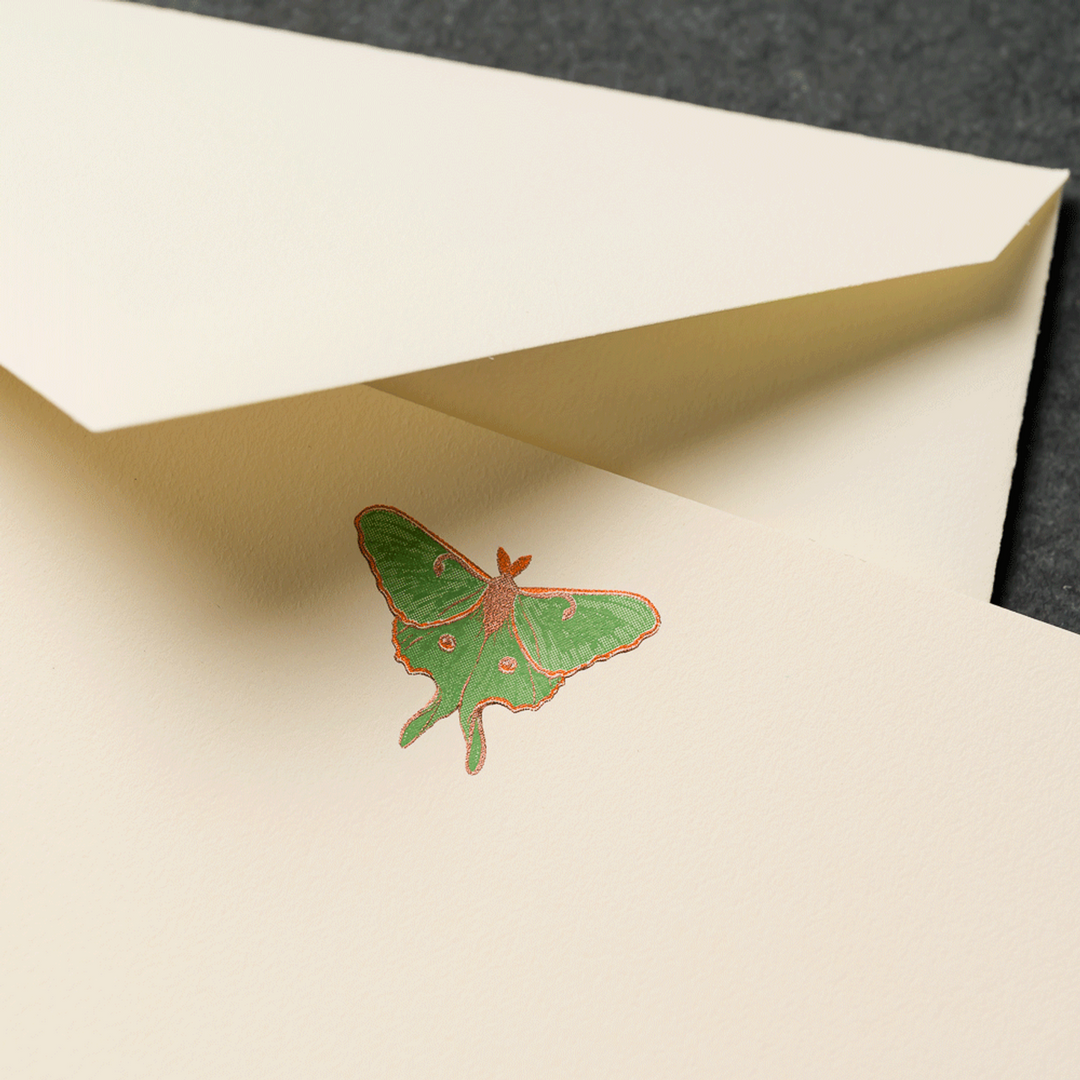 Green luna moth-shaped engaved motif on an ecru card with a matching envelope