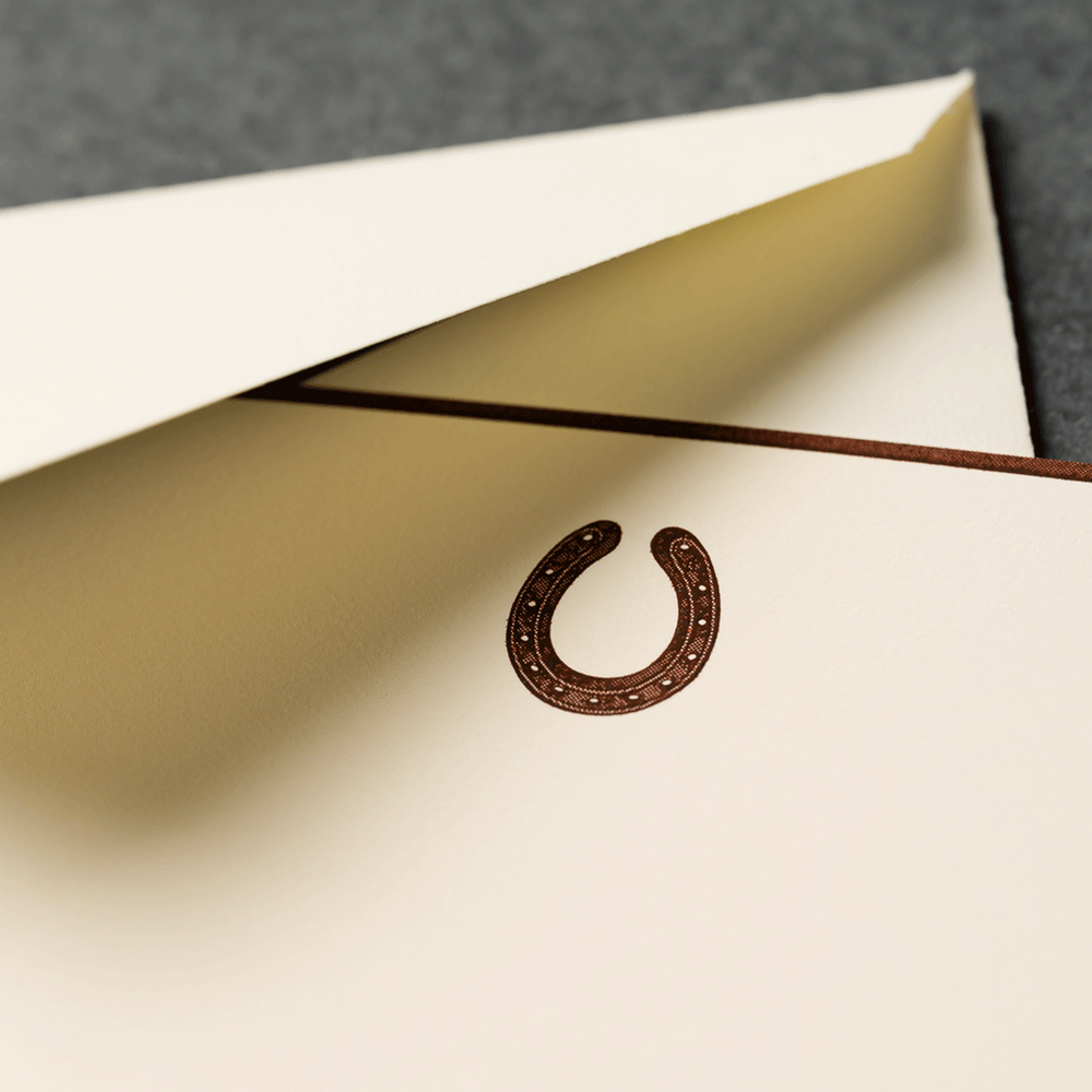 Close-up of a letter with a horseshoe engraved on a textured surface