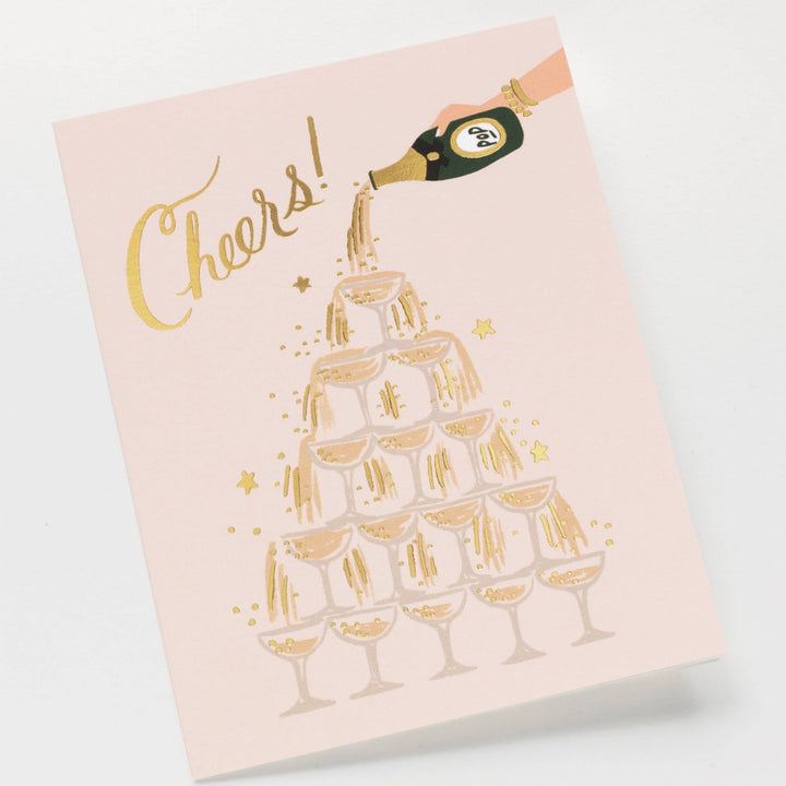 Card with gold foil design of champagne glasses and bottle, and 'Cheers!' text on a light pink paper
