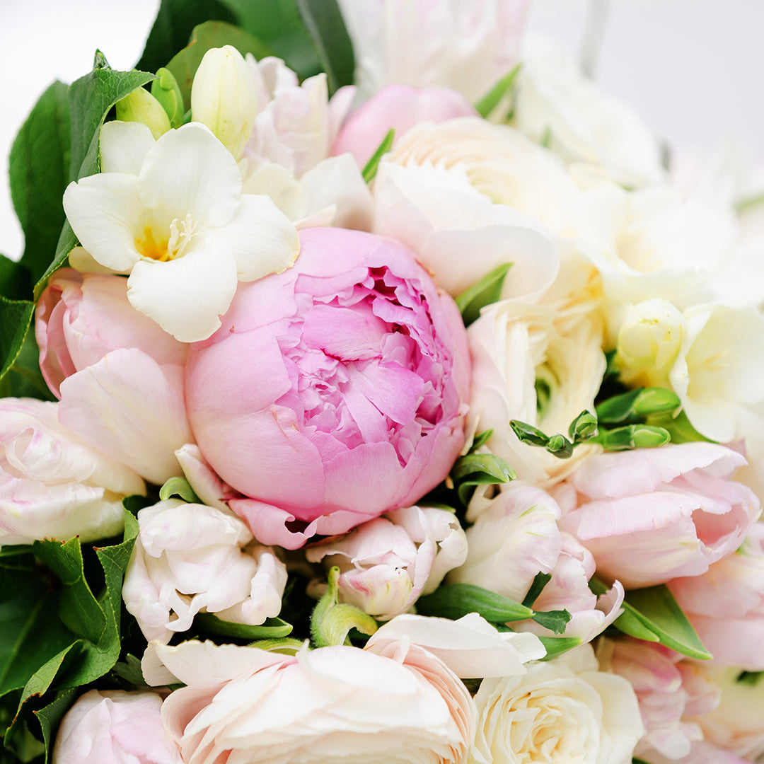 A mothers day bouquet of white roses and other flowers and pink peonies
