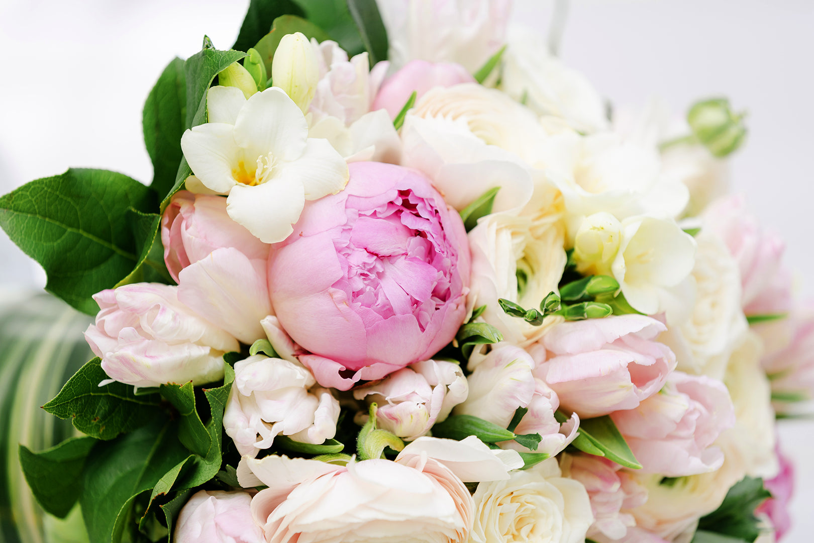 A mothers day bouquet of white roses and other flowers and pink peonies