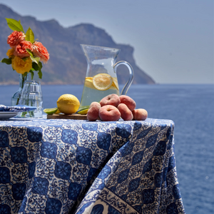 couleur nature azulejo blue tablecloth with pictcher and lemons and peaches and a bouquet 
