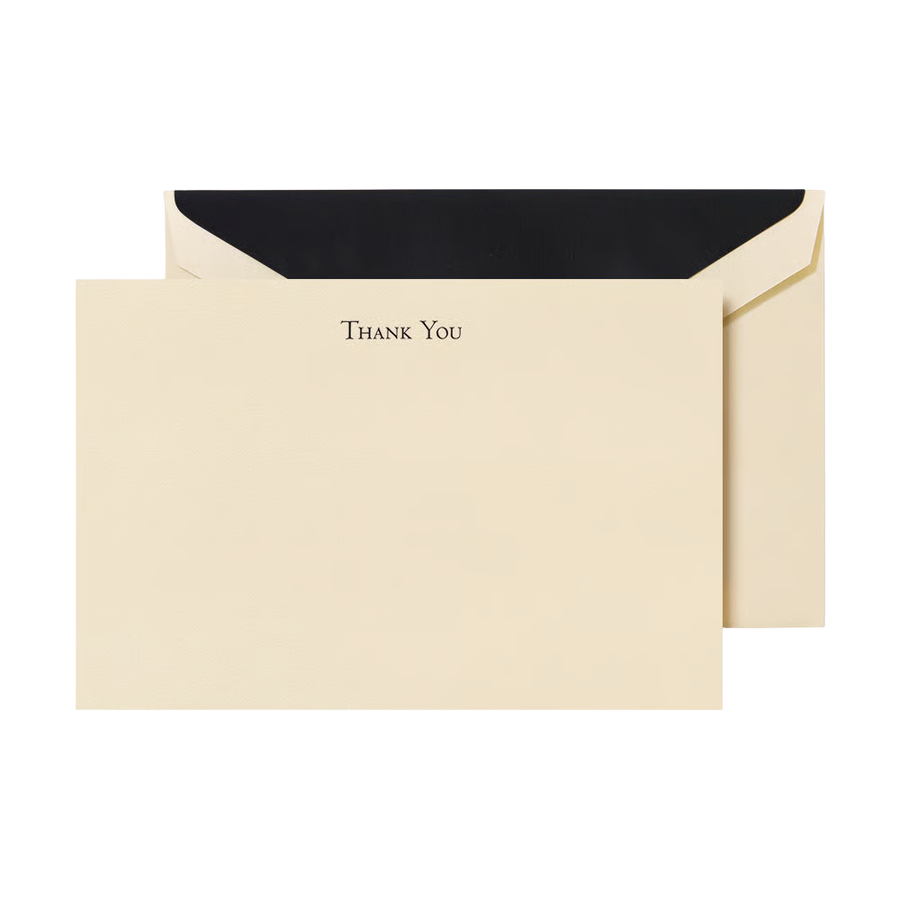 Ecru flat card with engraved black text reaiding "Thank You", sitting on top of a matching envelope with a black liner