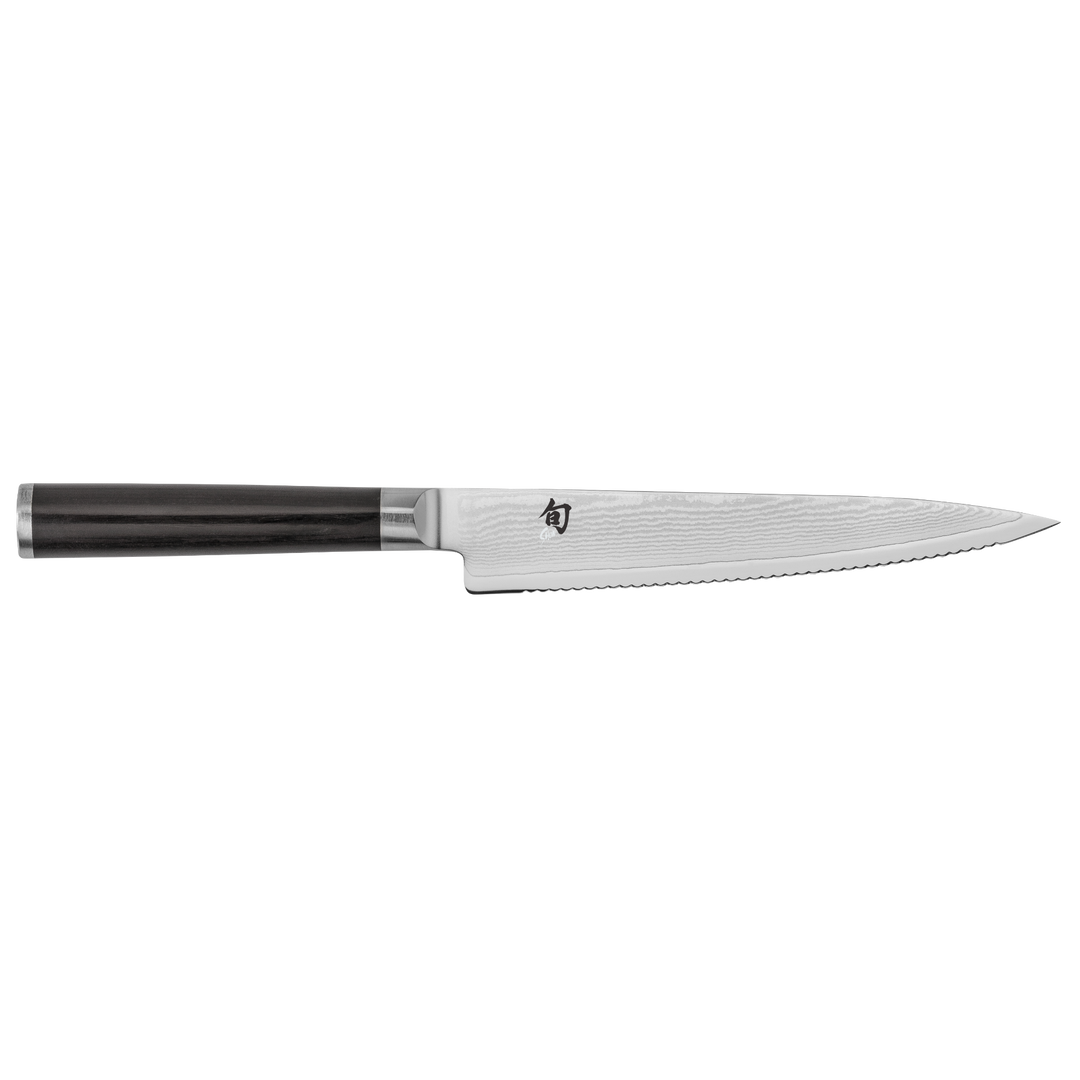 Serrated Shun knife with black handle on a white background