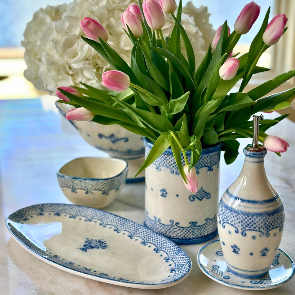Decorative table setting with blue and white patterned vases, platter, and tulips.