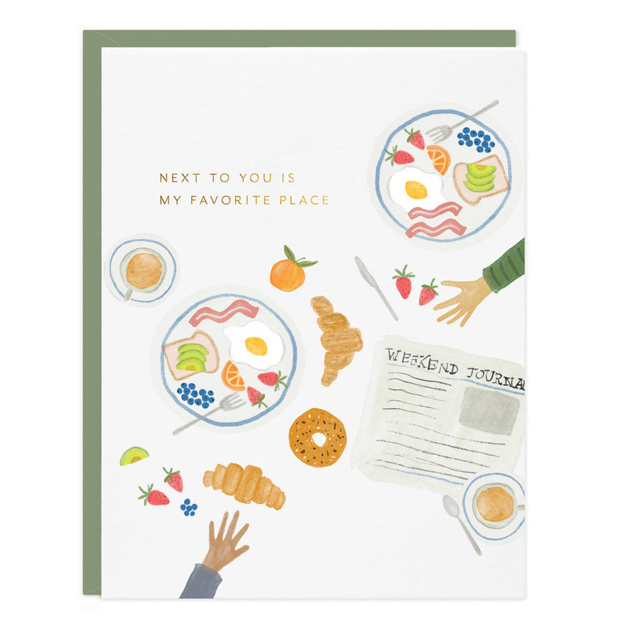 Greeting card with illustrations of food and a newspaper, featuring the text 'Next to you is my favorite place'.