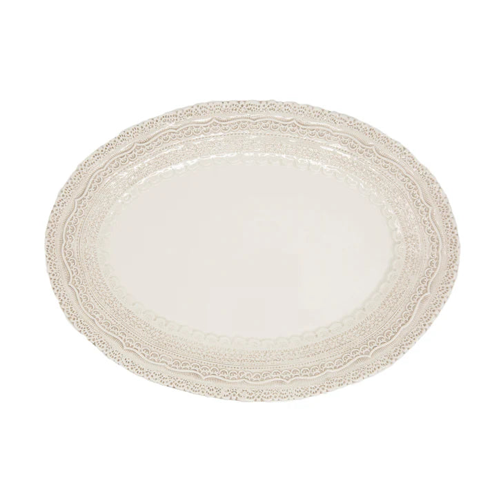 An of-white or cream colored platter with lace designs around the edge