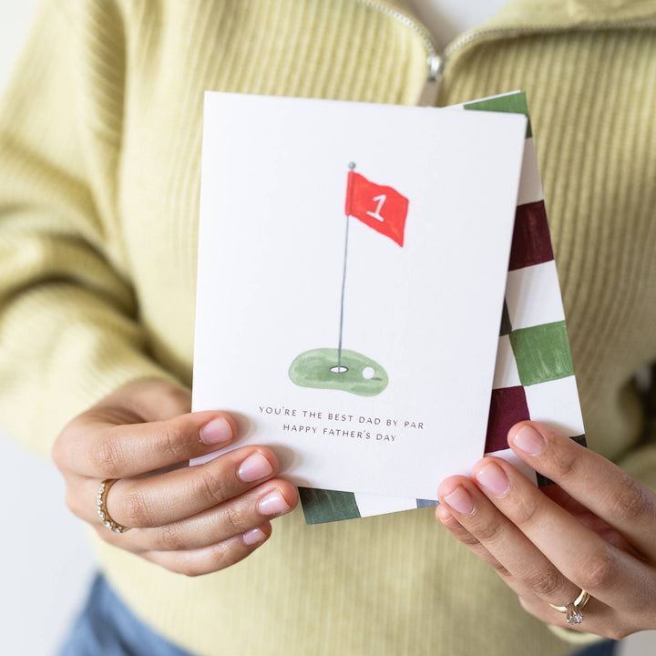 Person holding a Father's Day card with a golf design