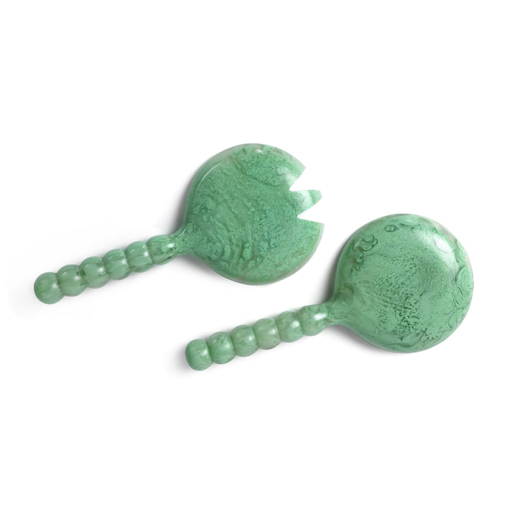 Two green jade massage tools on a white background