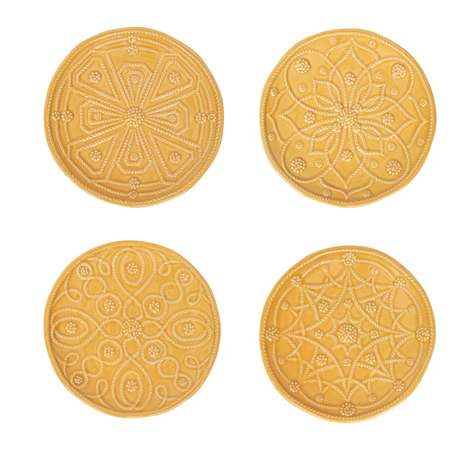 Four yellow plates with decorative patterns