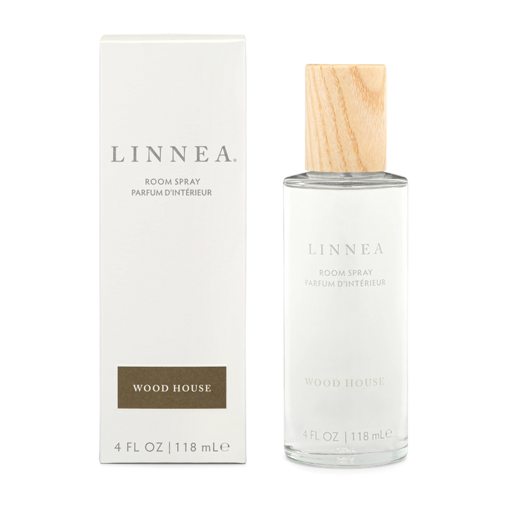 A bottle of Wood House linnea room spray next to its box