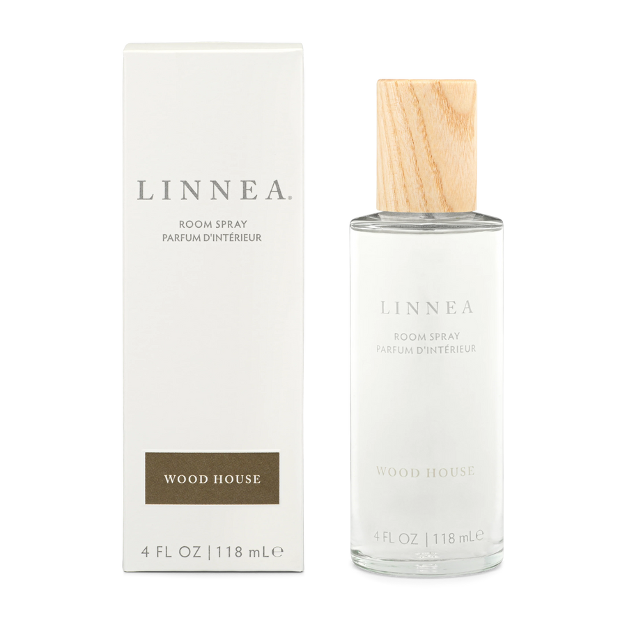 A bottle of Wood House linnea room spray next to its box