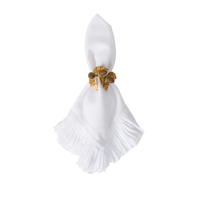 White folded napkin with a decorative gold napkin ring with an acorn and fall leaves design