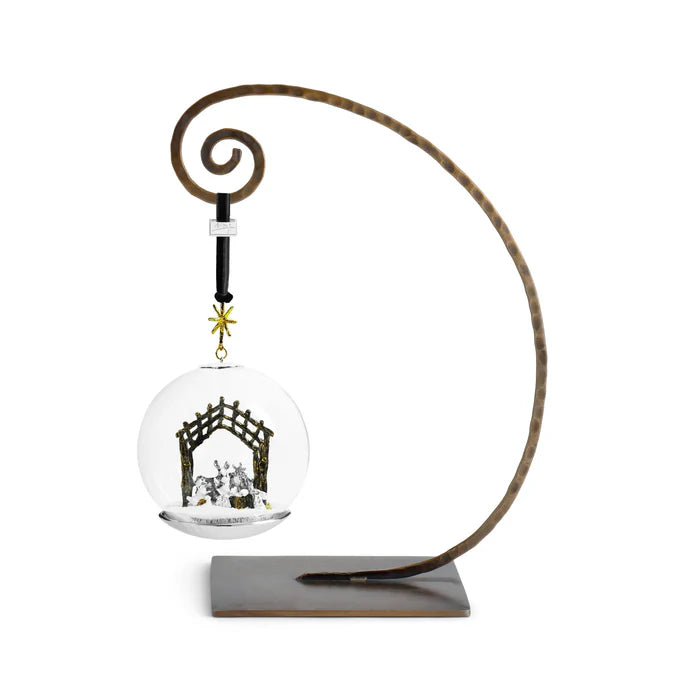 Snowglobe christmas tree ornament with nativity scene inside hanging from a brass hanger
