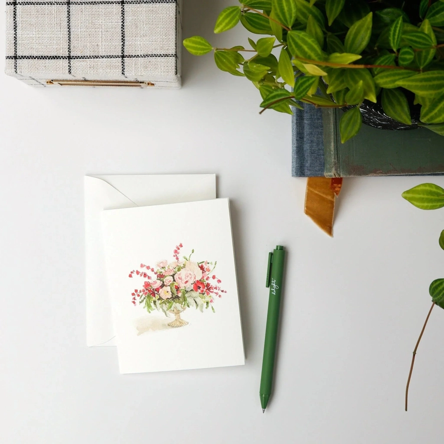 Greeting card with floral watercolor, pen, and plant  on a tabletop
