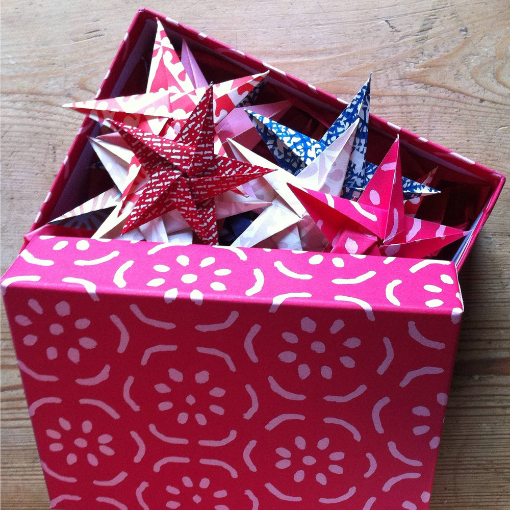 Pink box with star-shaped origami on a wooden surface