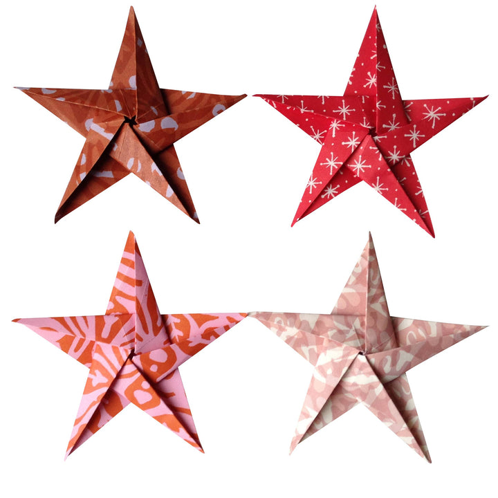 Four patterned red and pink paper stars on a white background