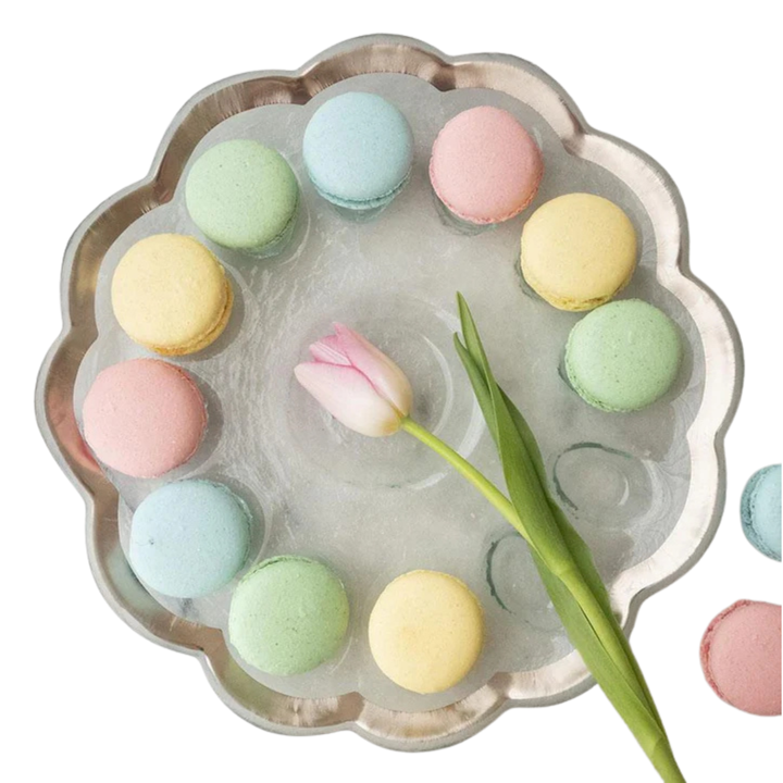 A glass dish with reccesses filled with pastel colored macarons