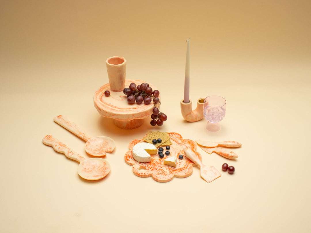 A pink set of cheese serving items 