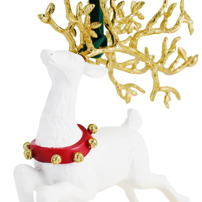 White reindeer ornament with a gold antlers and gold bells, against a gold branch background.