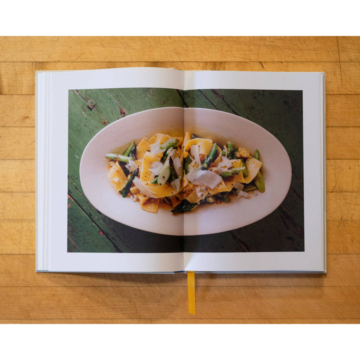 Open book showing a plate of food on a wooden surface