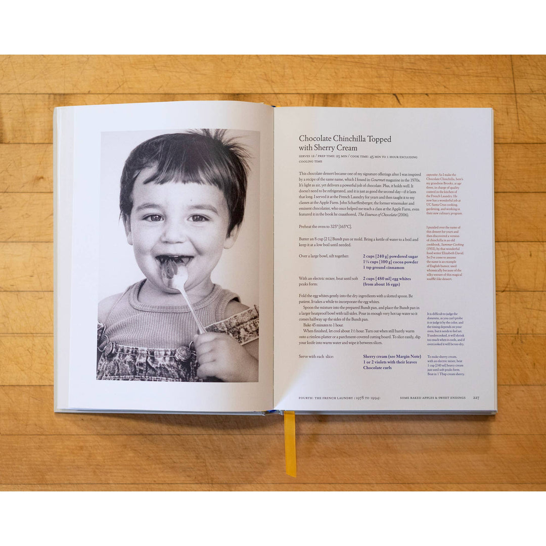 Open book on a wooden surface with a black and white photo of a child and text.