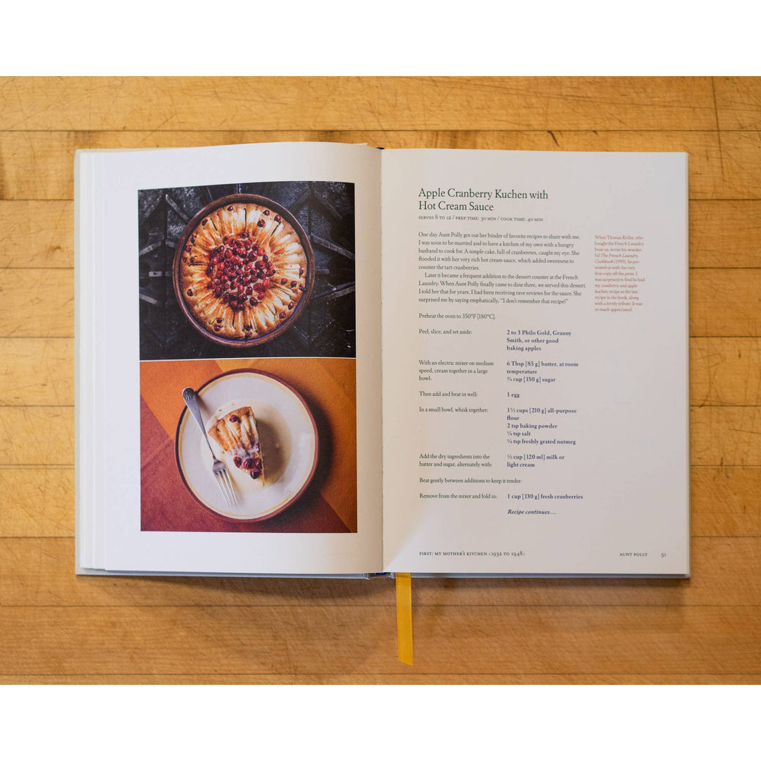 Open cookbook on a wooden surface with images of a dessert and text.