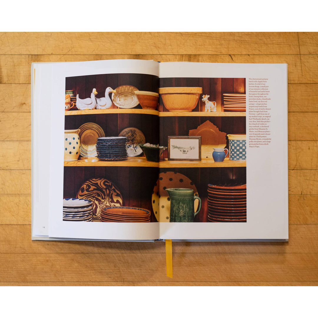 Open book showing images of ceramic dishes on a wooden surface