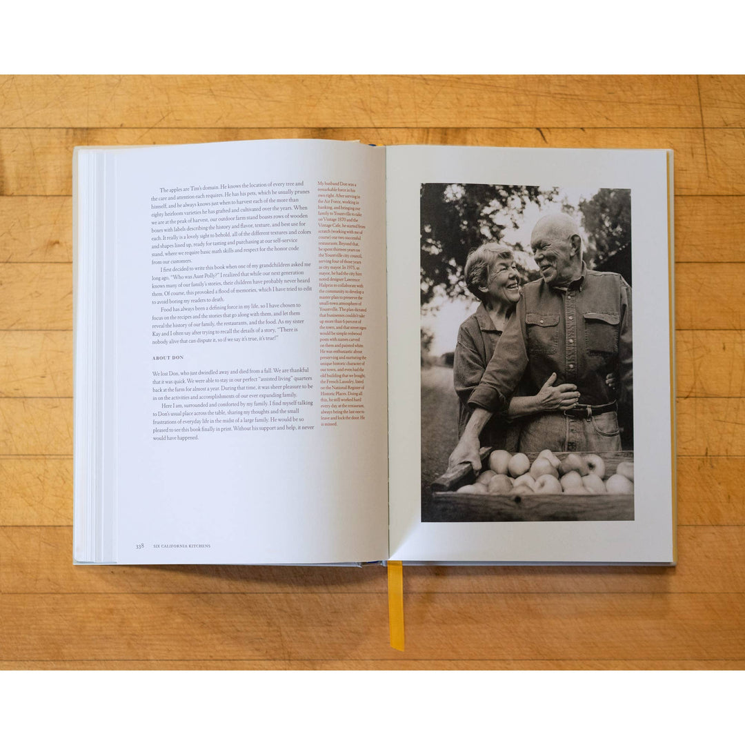 Open book on a wooden surface with a black and white photo of an elderly couple and text.