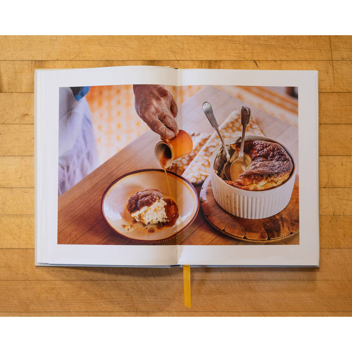 Open book showing a photo of a dessert being served on a wooden table