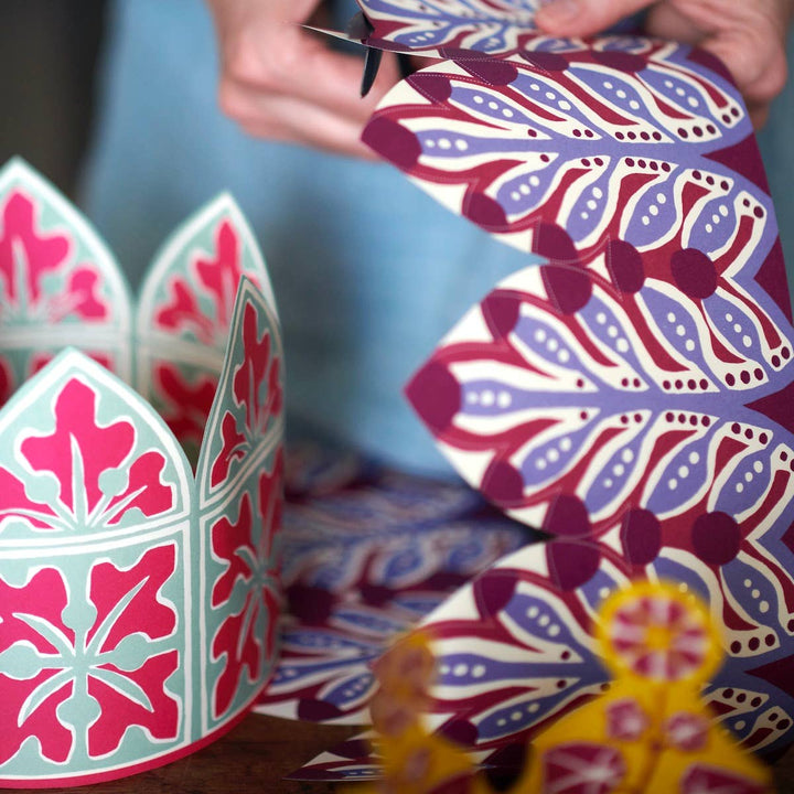 Colorful paper crowns with floral patterns  being assembled