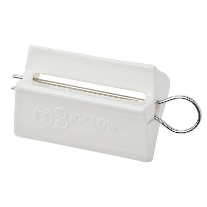 White C O Bigelow tool with a pin to roll a toothpaste tube and press out every bit of toothpaste