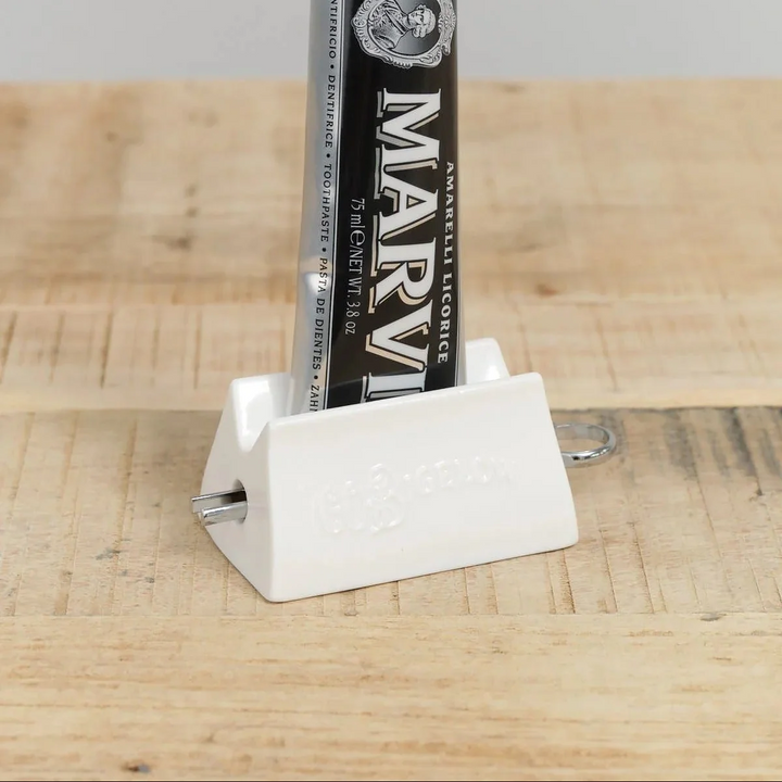 Marvis toothpaste tube in a white contraption that sqeezes out the last bit of toothpaste