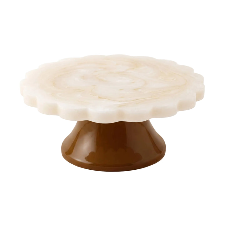 A scalloped round marble cake stand with a warm cream-white top and a glossy dark brown pedestal base, shown on a clean white background.
