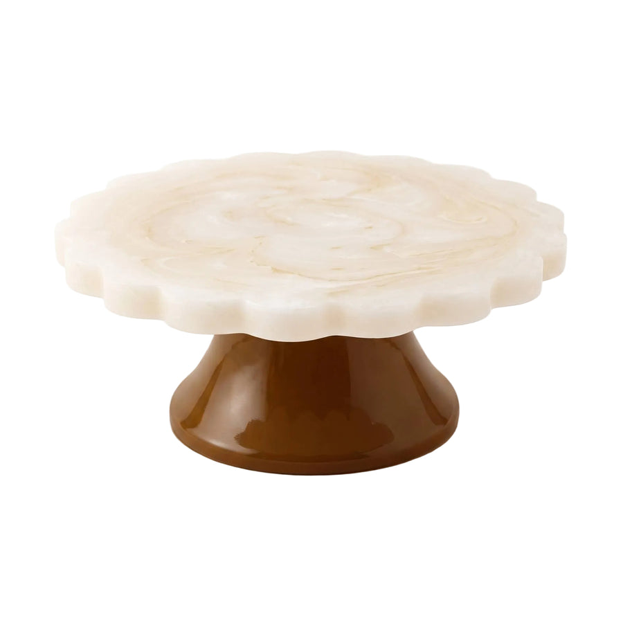 A scalloped round marble cake stand with a warm cream-white top and a glossy dark brown pedestal base, shown on a clean white background.