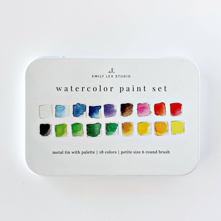 A watercolor paint set in a round metal tin with rounded corners