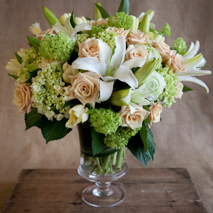 designers choice arrangement light pink roses white lillies green hydrangeas yellow tulips