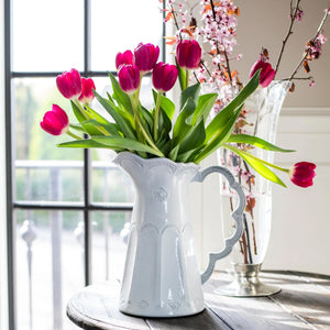 Arte Italica Merletto White Scalloped Pitcher with pink tulip flower arrangement